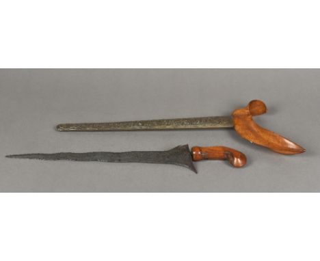 A 19th century South East Asian krisThe wavy steel blade patterned, the white metal scabbard embossed.  47.5 cm long overall.