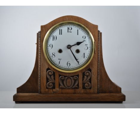 Oak cased mantel clock with Arabic chapter ring, twin train movement striking on a gong, carved panels to front, 29cm high.