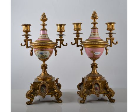 Pair of gilt metal twin light candelabra, fashioned as urns, pink Sevres style bodies with panels of nesting birds, raised on
