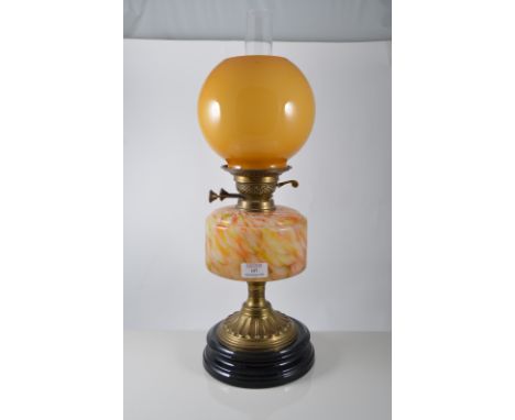 Victorian oil lamp, coloured glass reservoir, supported by a fluted flared foot on an ebonised base, amber glass globe shade,