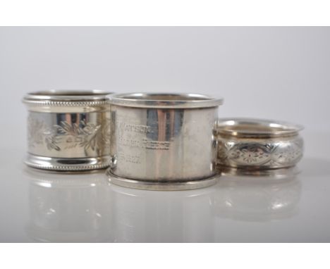 Edwardian silver napkin ring, bright cut scrolled decoration with beaded outlines, seven other silver napkin rings and two de