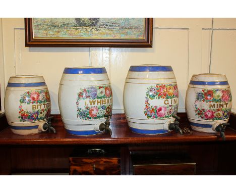 Four ceramic barrel decanters with floral panel decoration inscribed Gin and I Whisky, 32cm high, Bitters and Mint (a/f), 28c