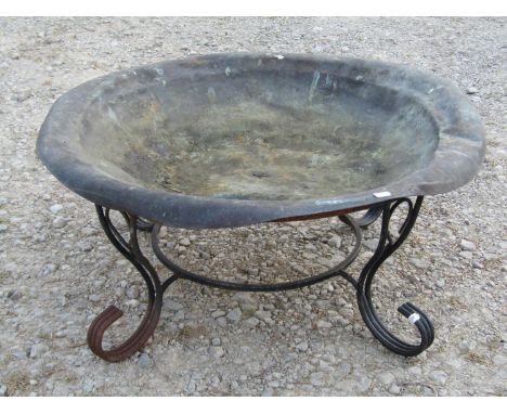 A shallow weathered circular copper water feature/planter raised on a loose associated scrollwork stand, 33 cm high x 75 cm i
