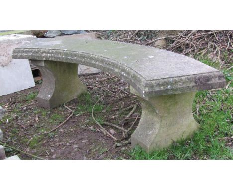 A 2000 centenary weathered three sectional cast composition stone garden bench with crescent shaped slab seat, 46 cm high x 1