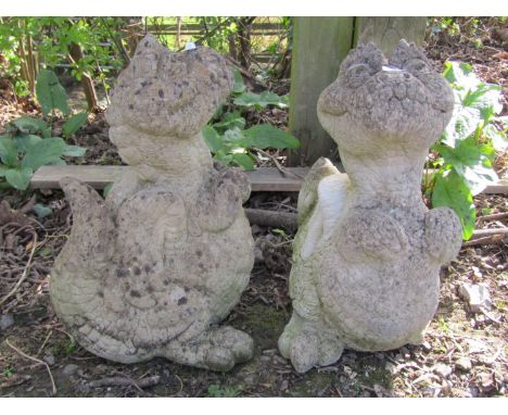 A matched pair of novelty weathered cast composition stone garden ornaments in the form of dragons, 40cm high
