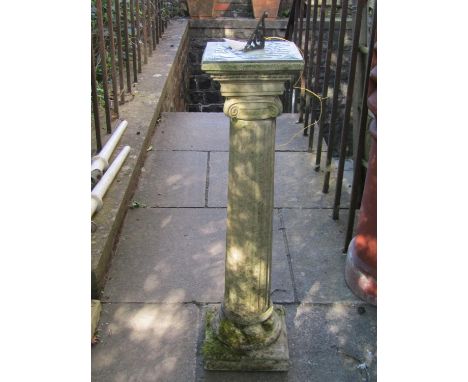 A weathered two sectional composition stone garden sundial, the pierced gnomon raised on a classical fluted column with Doric
