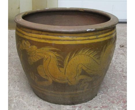 A large and impressive / oversized weathered salt glazed garden planter of tapering cylindrical form decorated with a dragon 