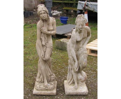 Two weathered cast composition stone garden ornaments in the form of classical scantily draped maidens in varying pose set on