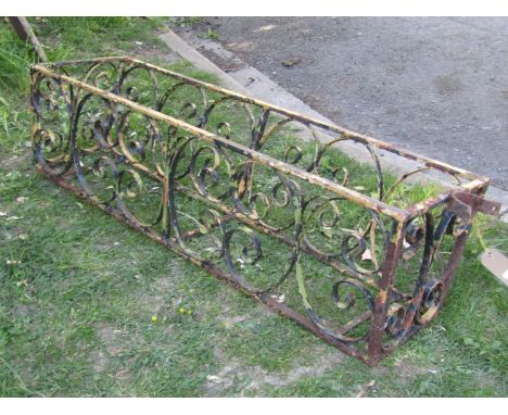 An old painted and weathered ironwork tapered rectangular flower trough frame/planter with decorative open scroll work detail