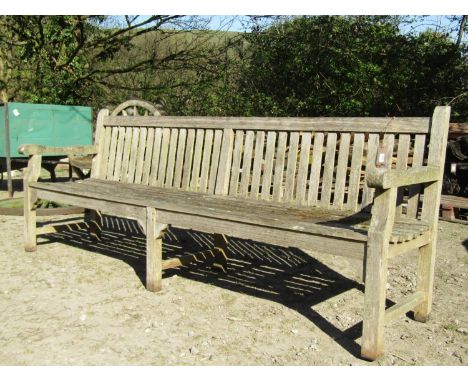 A large weathered / silvered teak park or country house garden bench, with slatted back and seat, 244cm long.