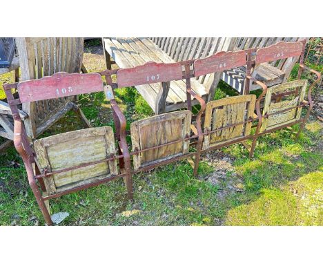 An old steel framed strapwork event bench with numbered panel backs, 204cm long x 82cm high (af)