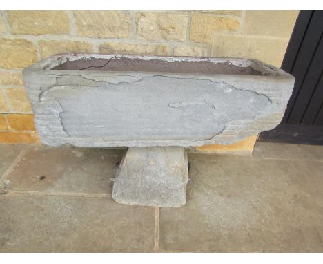 A roughly hewn weathered natural stone planter / trough of rectangular form raised on an associated tapering staddle base, 27