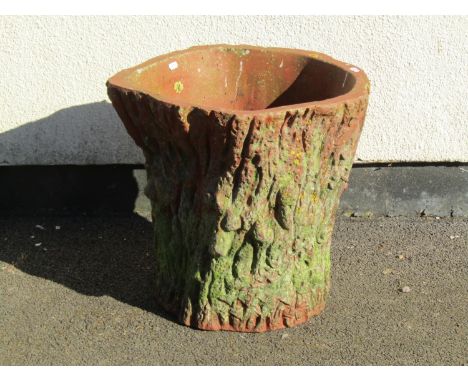 A weathered moulded terracotta garden planter in the form of a textured tree trunk / stump cross section, 47cm high, 50cm dia