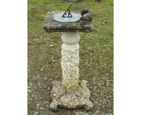 A weathered garden sundial with octagonal plate and pierced gnomon set on a two sectional cast composition stone base with bi