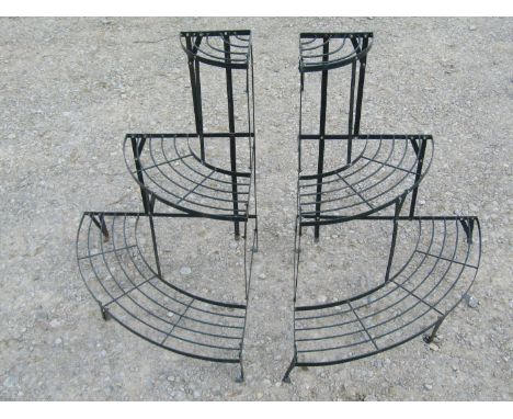 A pair of dark green painted light steel three tier bow fronted graduated plant stands 75 cm high x 84 cm x 59 cm 