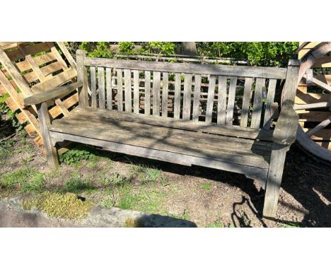 An old weathered/silvered teak garden bench with slatted back and seat, 191cm wide