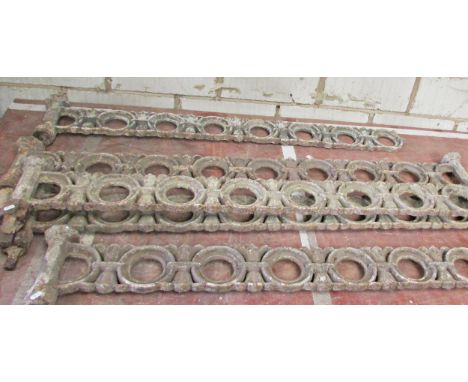 A run of five sections of 19th century cast iron wall top railing, formed of repeating pierced roundels interspersed with fle