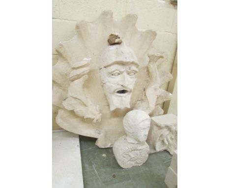 A collection of carved limestone and composite figures comprising a composite sun figure, a composite facial mask, unfinished