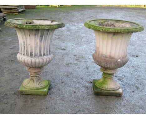 A pair of painted and weathered trumpet shaped and fluted garden urns with flared rims and loose square base socles (af), 75 