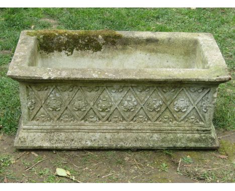 A weathered rectangular cast composition stone planter with repeating lattice and flowerhead detail, 31cm high x 76cm x 39cm