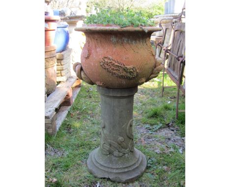 A squat oviform terracotta planter with combed bark effect and twisted handles raised on a pedestal, 58cm high x 31cm diamete