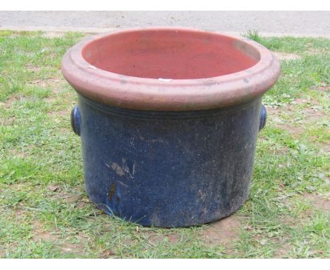 A blue glazed squat cylindrical terracotta planter with moulded rim and handles, 35cm high x 48cm diameter