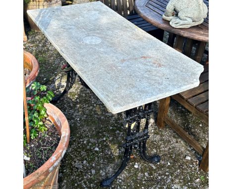 A Victorian cast iron table base with swept supports, trailing foliate detail and balustrade stretcher, beneath a fixed possi