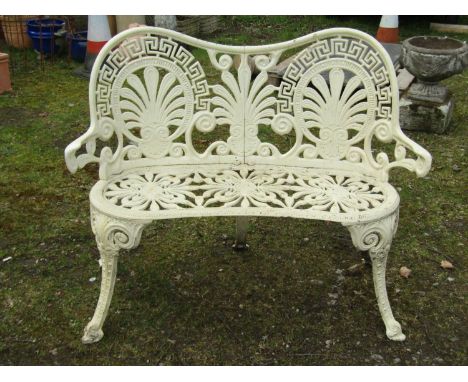 A decorative cream painted cast alloy two seat garden bench with shaped outline and pierced foliate and geometric detail, 85 