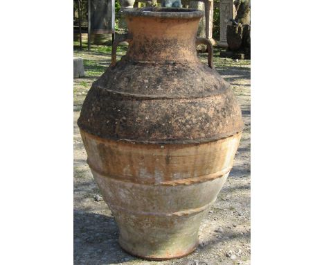 A large and impressive Mediterranean ovi-form weathered terracotta jar with moulded loop handles and pinch banded detail, 91c