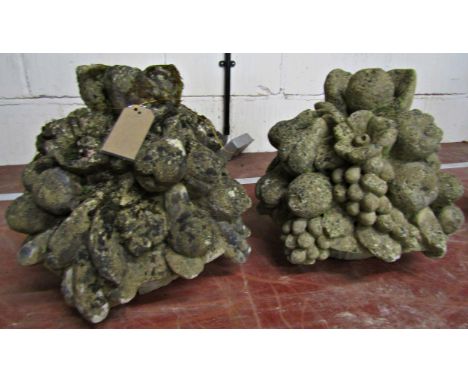 A pair of weathered composition stone finial / caps in the form of fruit-laden cornucopia, each 33 cm high (2)