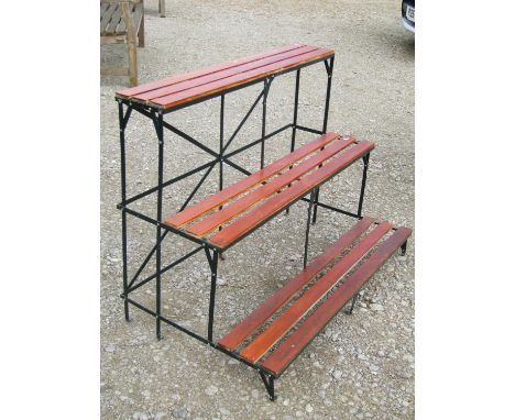 A dark green painted light steel strapwork framed three-tier plant stand with stained wooden slats 76 cm high x 100 cm x 60 c