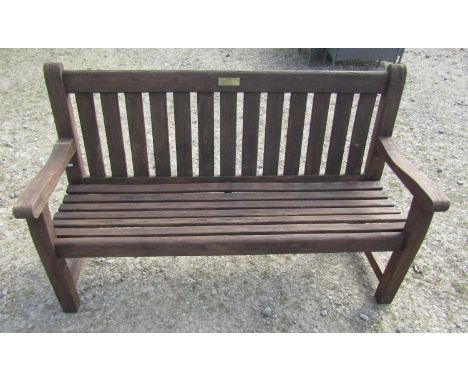 A 'Woodfurn' stained and weathered teak three seat garden bench with slatted seat and back, 150 cm long