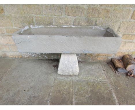 A weathered natural stone planter / trough of rectangular form raised on an associated staddle base, 18cm high, 99 x 37cm, 54