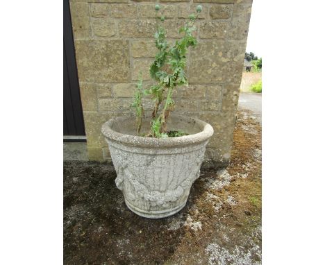 A pair of weathered cast composition stone planters of tapering cylindrical form with moulded garland swag motifs 50cm high, 