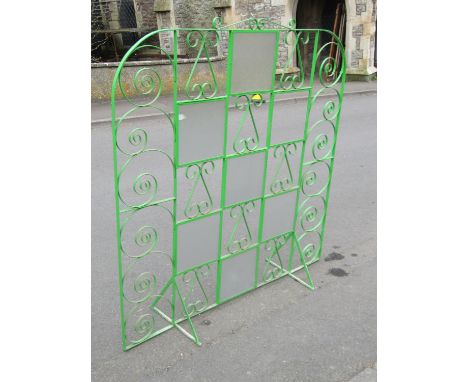 A light green painted ironwork freestanding screen with decorative open scroll work and glass panels, 160cm high x 151cm