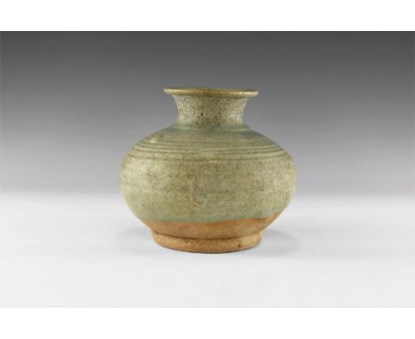 13th-16th century AD. A green glazed Sangkhalok Celadon ware vase with flaring mouth, narrow neck, bulbous body with ribbing 