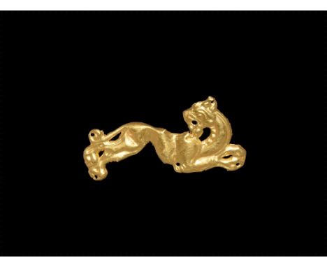 8th-4th century BC. A gold foil plaque with openwork design of a leaping feline with head regardant, legs and tail extended; 