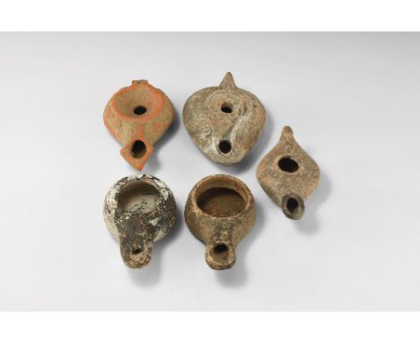 5th century AD. A mixed group of ceramic lamps comprising: one slipper-shaped with lug handle; two drum-shaped with long nozz