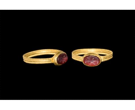 2nd-3rd century AD.
A gold ring with rope pattern shank, bezel set with red glass intaglio engraved with double headed Capric