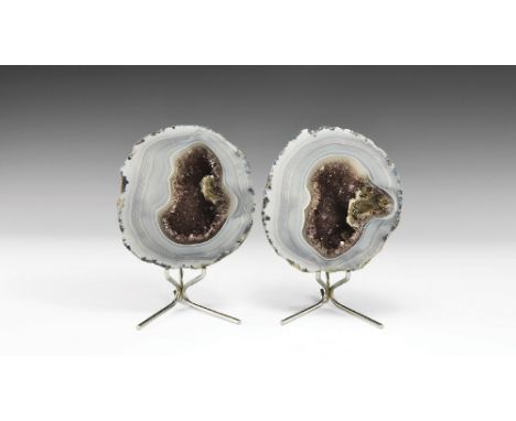 A pair of sawn and polished blue agate geodes filled with amethyst, the agate multi-layered, the layers so thin that they pro