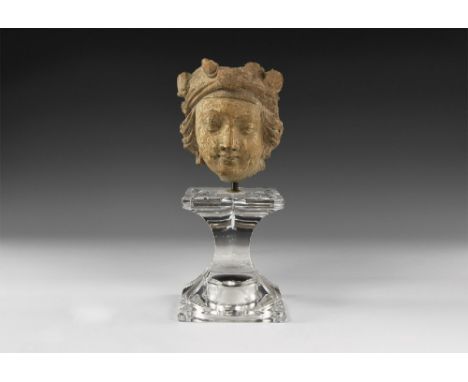 2nd-3rd century AD. A ceramic head of a bodhisattva, possibly Maitreya, with soft, Hellenistic features, hair arranged and bo