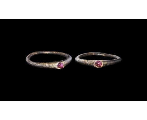 14th century AD. A narrow D-section elliptical silver-gilt hoop with triangular plaque, inset amethyst cabochon to the apex. 