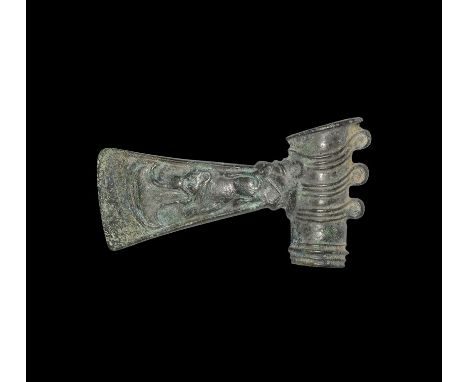 1st millennium BC. A bronze axehead with flaring blade decorated with a crouching lion with hooked axe shape coming out of it