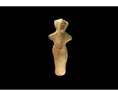 Neolithic, 6th-4th millennium BC. A ceramic figurine of a standing female with triangular face, arms extended, incised detail