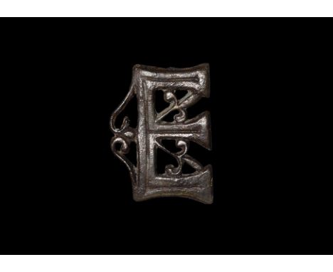 14th-16th century AD. A Westminster Abbey openwork belt mount of a capital 'E' with fleur-de-lys tracery ornamentation; the i