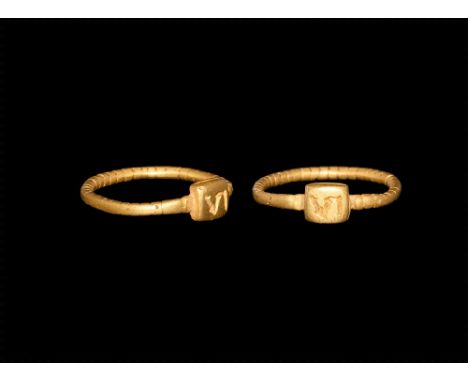 4th century AD.
A round-section beaded gold hoop with separate stepped square bezel, inscribed 'VI'. 3.54 grams, 21mm overall