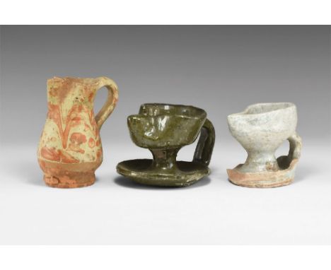 12th-14th century AD. A group of ceramic items comprising: blue glazed oil lamp with chipped pedestal, green glazed oil lamp 