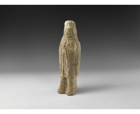 Northern Qi Dynasty, 550-577 AD. A ceramic figure of a standing soldier wearing a long robe down to the knees, cape tied at t