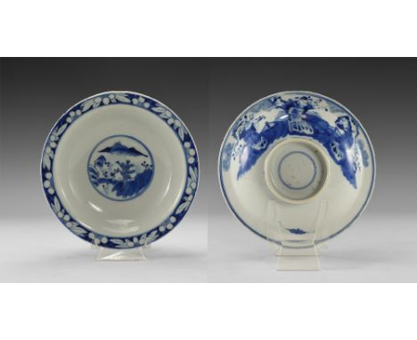 17th-18th century AD. A broad shallow glazed ceramic bowl with tubular foot, reserved flowers to the rim, landscape with tree