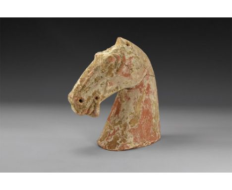 Han Dynasty, 206 BC-220 AD. A hollow-formed ceramic horse's head with pierced flange above. 486 grams, 14.5cm (5 3/4"). Ex Ki